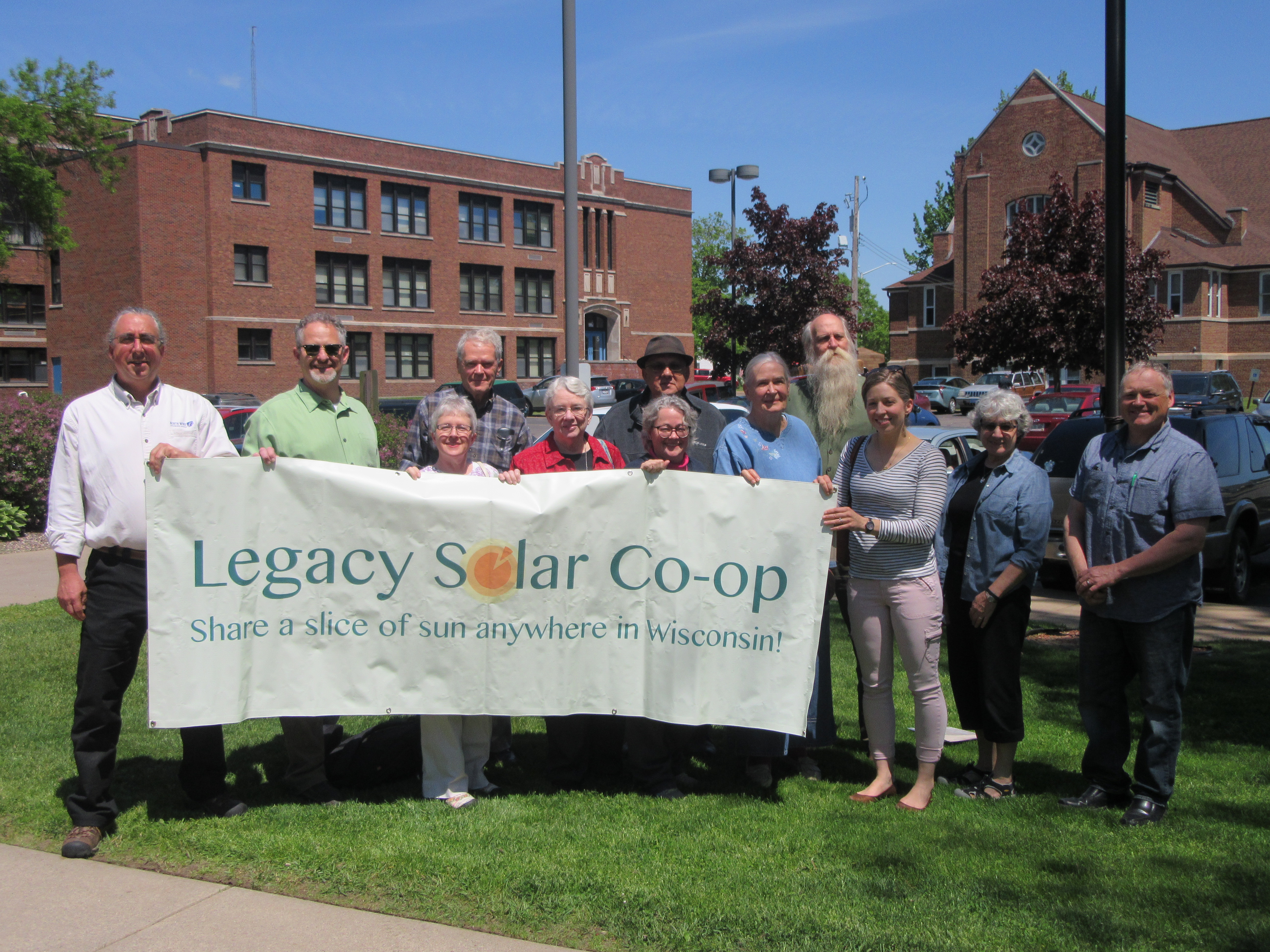 12 Local members of Legacy Solar Co-op standing in front of Legacy Co-op sign