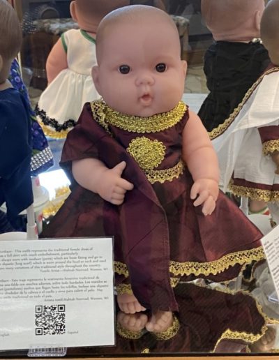 Display case showing a doll wearing traditional clothing