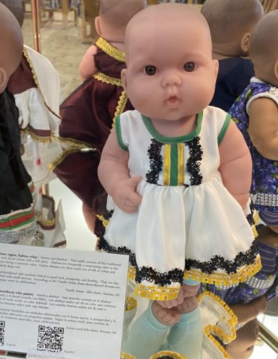 Display case showing a doll wearing traditional clothing