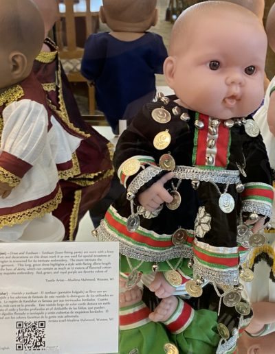 Display case showing a doll wearing traditional clothing