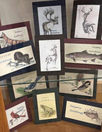 A display case showcasing holiday cards featuring various animals and pictures, highlighting their festive designs.