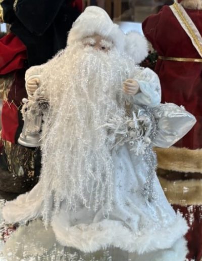 A charming Santa Claus figurine is prominently featured in a glass case, emphasizing its holiday spirit and artistry.