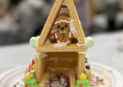 A gingerbread house that has a gingerbread man stuck in the attic.