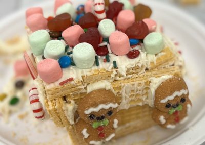 A charming gingerbread house embellished with vibrant candies and soft marshmallows, perfect for the holiday season.