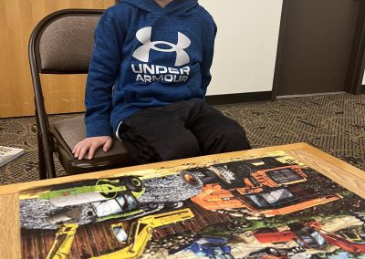 A young boy showing his completed puzzle