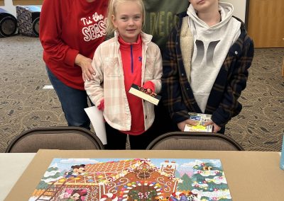 A joyful family gathers around a vibrant puzzle, posing for a fun photo with big smiles on their faces.