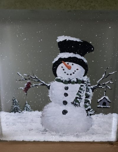 A decorative glass block showcasing a delightful snowman, perfect for celebrating the winter season.